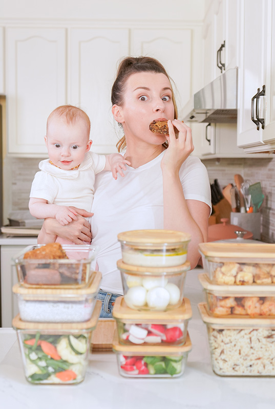 Mom with baby in organized kitchen with meal prep containers